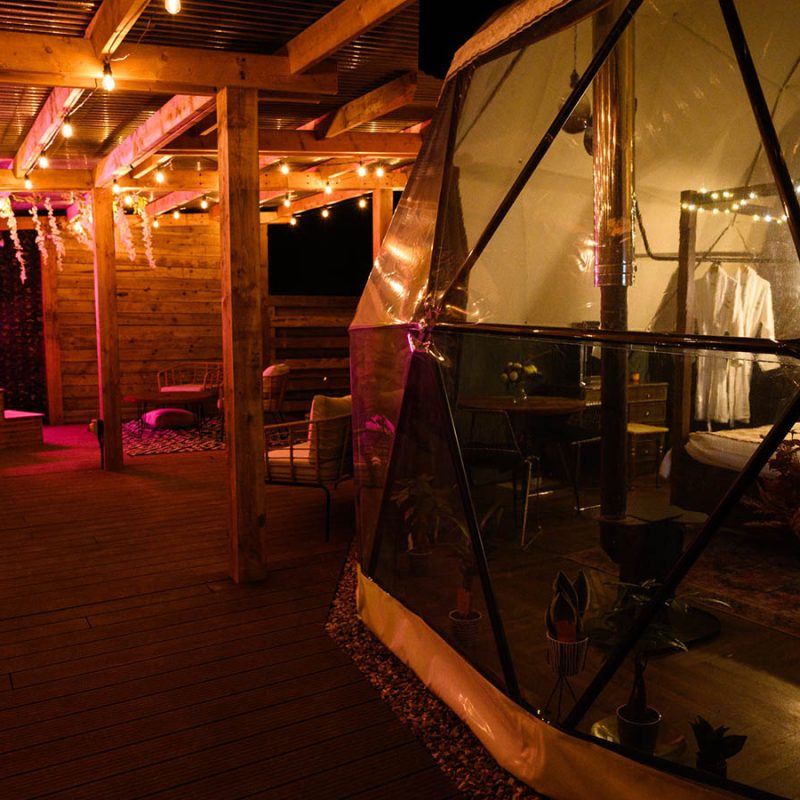The outdoor area and lit up dome at Hillside Haven glamping dome at Coorie Retreats