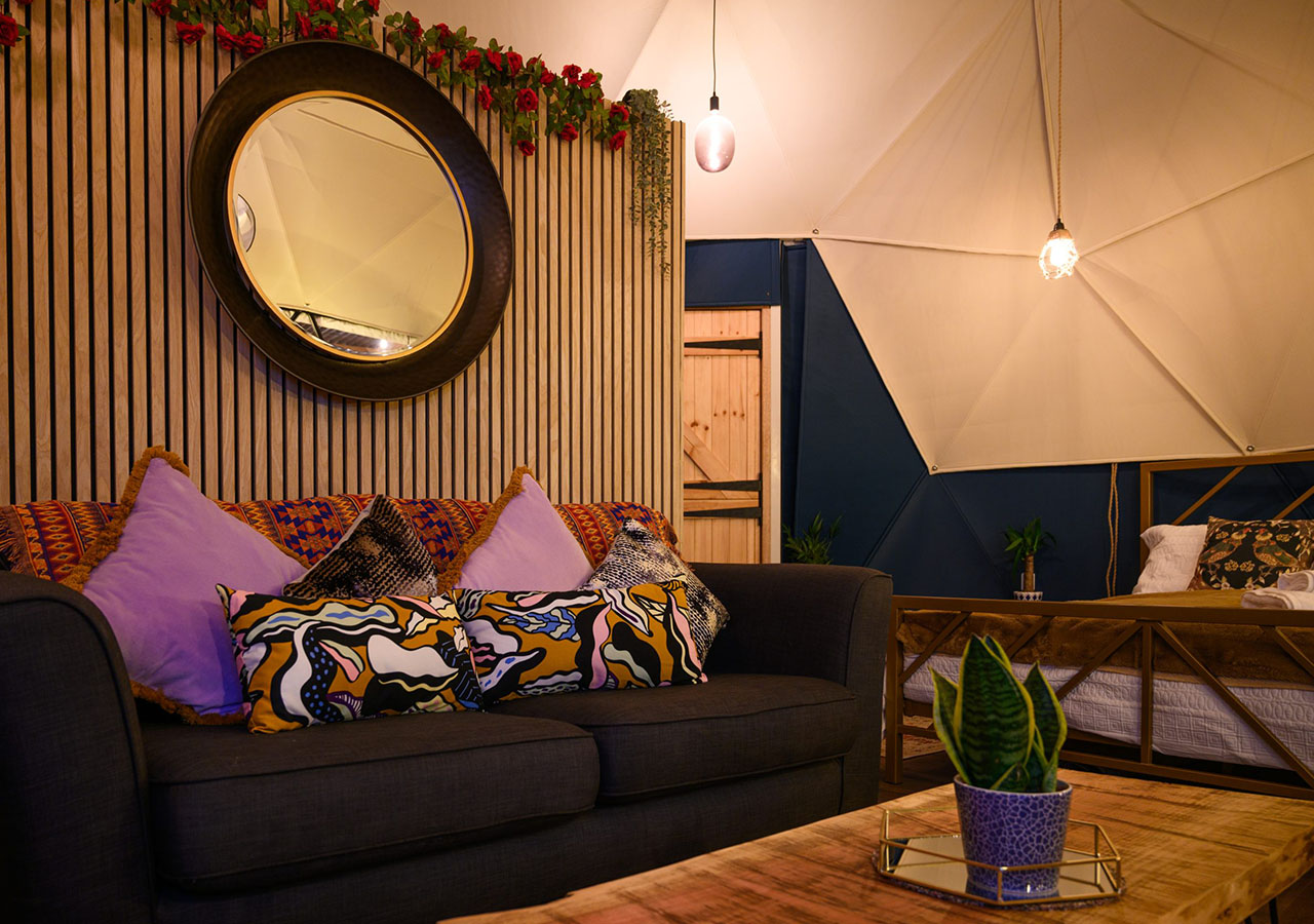 The seating area with the bed in the background in Dalriada Den glamping dome at Coorie Retreats