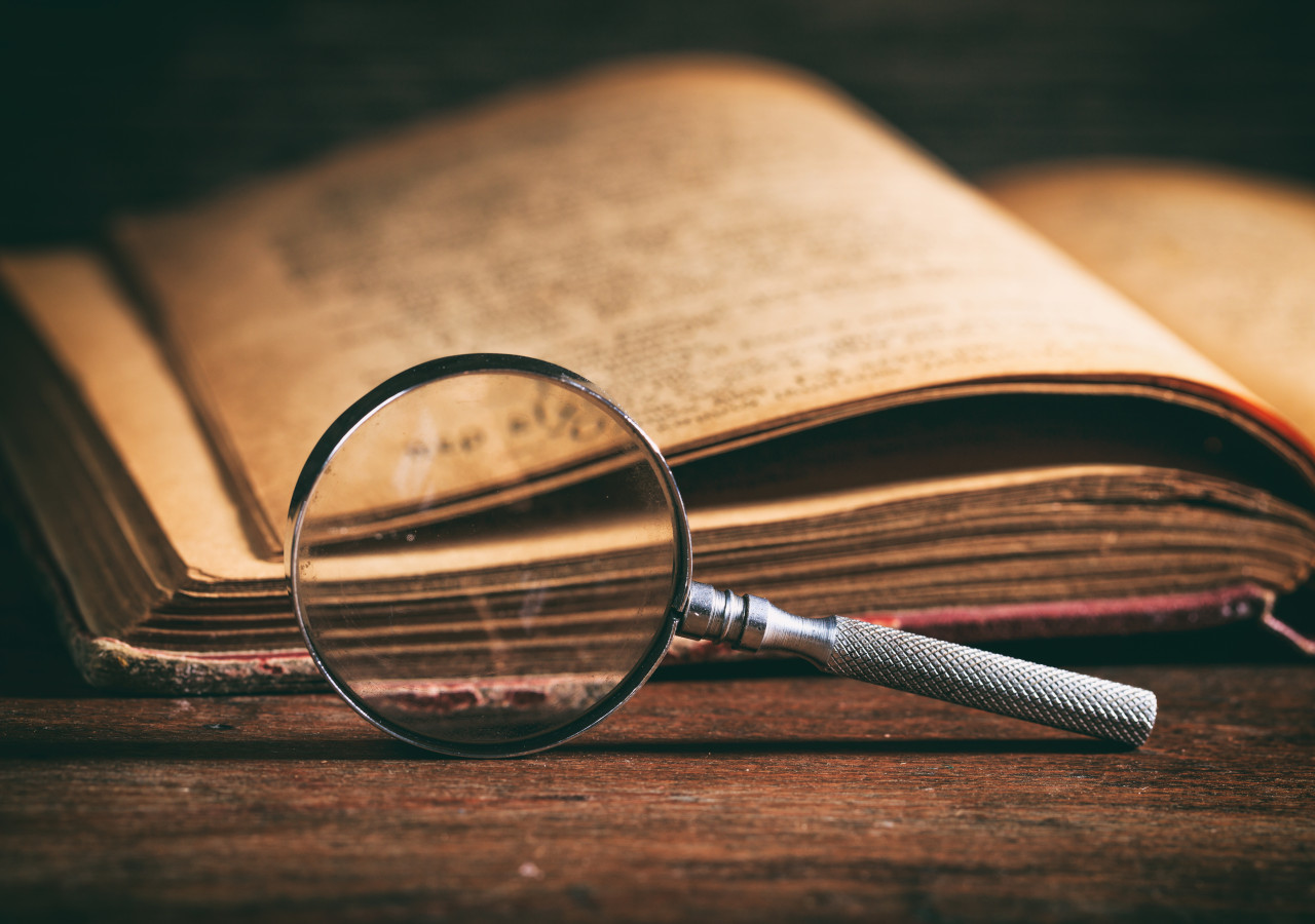 Old book and magnifying glass