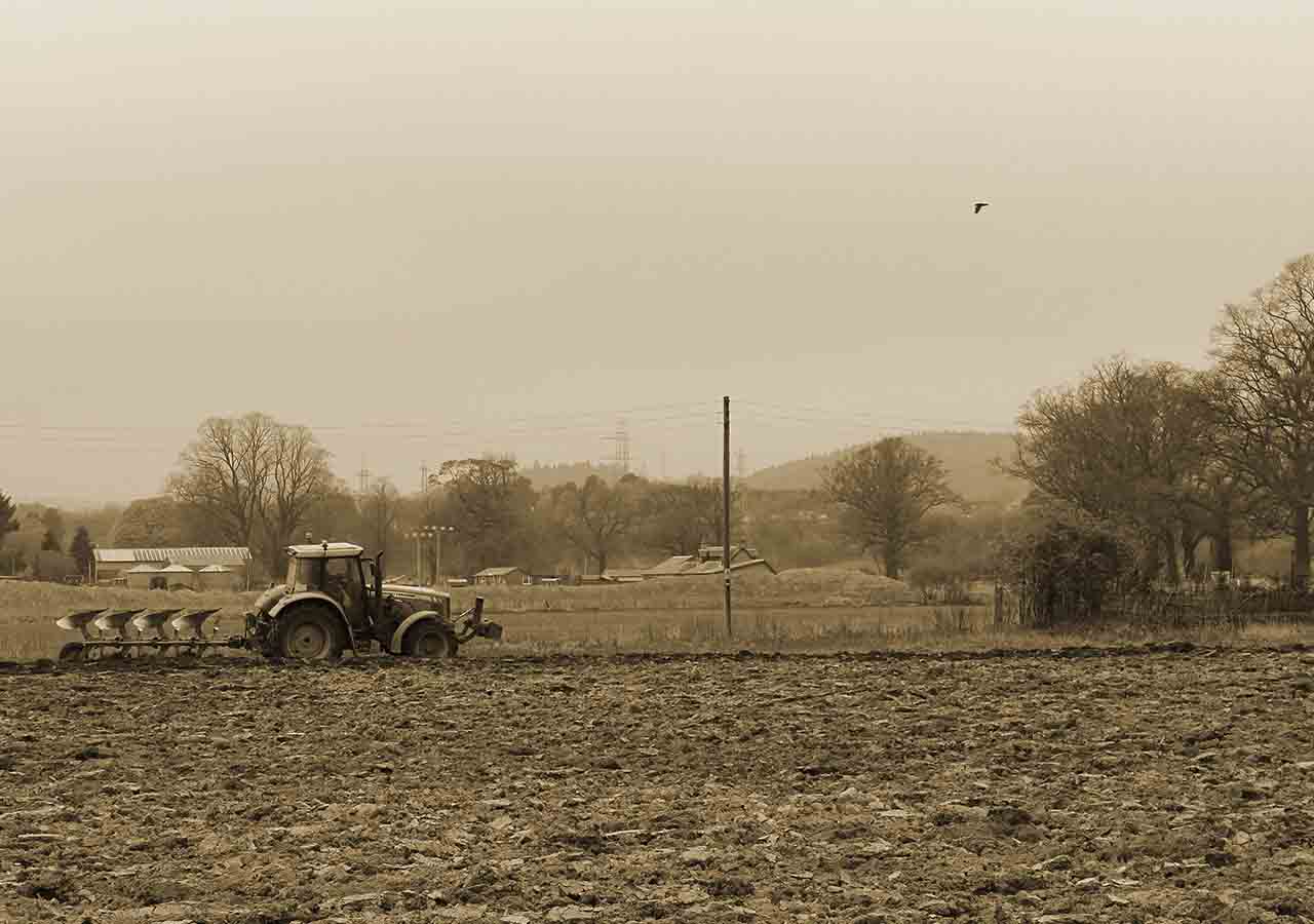 An old photo of a tractor in a field.