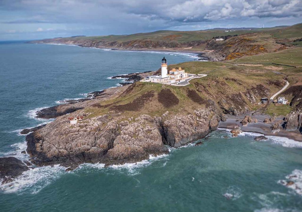 Killantringan Lighthouse in Dumfries and Galloway, surrounded by choppy sea.